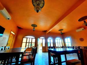 梅尔祖卡Riad family的用餐室设有橙色墙壁和桌椅