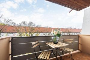 慕尼黑Homaris Apartments München Laim的阳台配有桌椅和花瓶