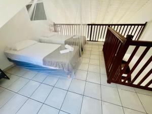哥西尔Bel appartement cosy - Les pieds dans l'eau的一间带两张床的卧室,铺有瓷砖地板。