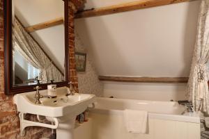 Swanton MorleyCarrick's at Castle Farm的浴室配有盥洗盆和浴缸。