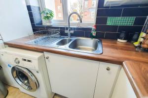 切尔滕纳姆Captivating 4-Bed House in Cheltenham的厨房配有水槽和洗衣机