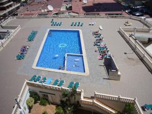 贝尼多姆Torre Principado II - Fincas Arena的游泳池的顶部景色,设有椅子和人