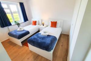 切尔滕纳姆Captivating 4-Bed House in Cheltenham的一间卧室设有两张带蓝色靠垫的床和窗户。