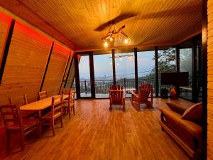 巴统Dream Panorama Cottage的一间带桌椅和窗户的用餐室