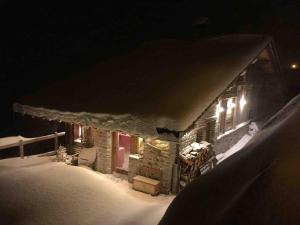 蒙特瓦勒赞La Rosière Magnifique chalet savoyard 160 m2 T5的雪覆盖的房屋,晚上有灯