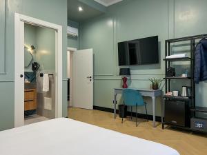 博洛尼亚Mondo7的一间卧室配有一张床、一张书桌和一台电视。