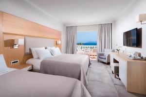 卡尔扎迈纳Porto Bello Royal的酒店客房设有两张床和电视。