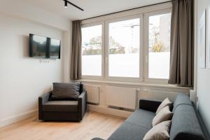 汉堡Homaris Apartments Hamburg Altona的带沙发、椅子和窗户的客厅
