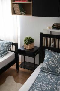 萨格勒布2-Bedroom Apt Near City Center的一间卧室配有一张床和一张桌子,上面有植物