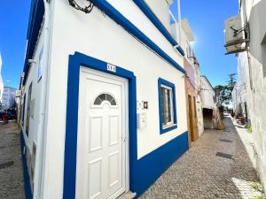 奥良Olhão Beach Apartment 2 by Homing的白色和蓝色的建筑,有门