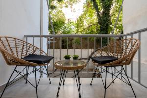 雅典Charming two bedrooms Apartment walk to Acropolis的阳台配有2把椅子和1张桌子
