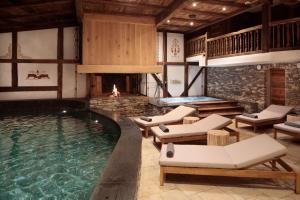 克莱恩 蒙塔纳Aïda Hôtel & Spa - "Adults Only" Relais & Châteaux的一个带躺椅和壁炉的游泳池