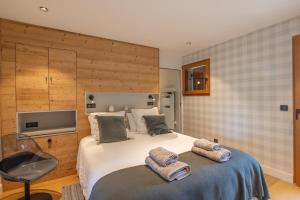 欧特吕斯Chalet Les Galetas du Mont Blanc的一间卧室配有一张床,上面有两条毛巾