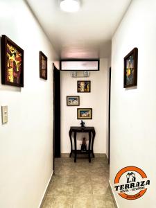 基多Hostal La Terraza的走廊上设有桌子和墙上的照片