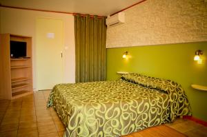 乌尔坦皮斯酒店的一间卧室设有一张床和绿色的墙壁