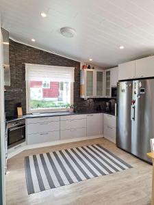 TaivalkoskiTaivalviiri的厨房配有白色橱柜和不锈钢冰箱