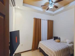 利比里亚Apartment Equipped With Excellent Location的一间卧室配有一张床和吊扇