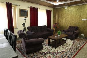 斯利那加Khwaab Gah by The Khayabaan-HomeStay 3 BHK, 2 BHK & 1 BHK Apartments in City Centre的客厅配有沙发、椅子和桌子