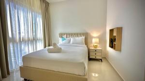 迪拜Calm Chaos 4 BR Villa with maid Room in Damac Hills 2的白色的卧室设有一张大床和一个窗户