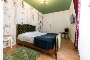 布拉索夫卡萨安堤瓜旅馆的一间卧室配有一张带绿色床头板的床