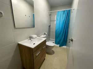 BúbalComplejo Bubal Formigal 3000的浴室设有水槽和带蓝色淋浴帘的卫生间。
