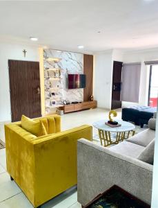 拉各斯VI/Ikoyi/Oniru Lagos Property的客厅配有黄色的沙发和桌子