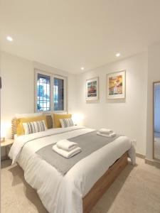 卡西斯L'Ipanema - Standing T2 + Balcon的白色卧室配有一张大床和毛巾