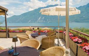 利莫内-苏尔加达Hotel Ilma Lake Garda Resort的一个带桌椅和遮阳伞的庭院