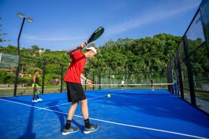 梵蒂冈角Villaggio Torre Ruffa的网球运动员在网球场上手持网球拍