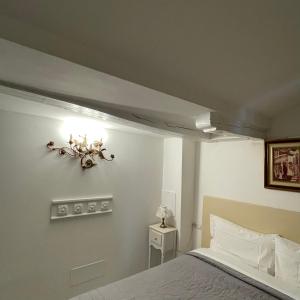 波代诺内MANTICA CATTANEO APPARTAMENT的卧室配有一张床,墙上有灯