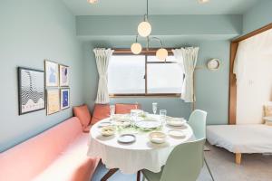 东京HARMONIA東京堀切502的一间配备有白色桌子和沙发的用餐室