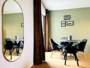 凯恩Bel appartement rénové dans une résidence calme的一张镜子,一张桌子和椅子
