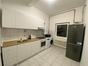 新明斯特3-SZ Monteurwohnung am Hansaring的厨房配有白色橱柜和黑色冰箱。