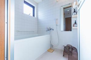 东京HARMONIA東京堀切502的白色的浴室设有浴缸和水槽。