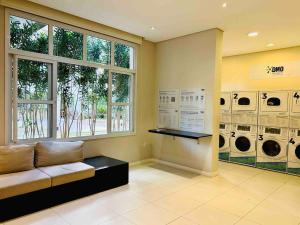 瓜鲁柳斯Apartamento 408 em condomínio de alto padrão的带沙发和多台洗衣机的洗衣房