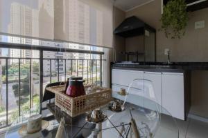 瓜鲁柳斯Apartamento 408 em condomínio de alto padrão的厨房配有玻璃桌和窗户