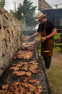 拉库布蕾Posada Punta de Piedra的男人在烤架上烹饪肉