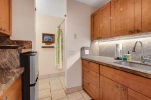 科纳Kona Islander Inn 147 Tropical Oasis的一个带木制橱柜和水槽的厨房