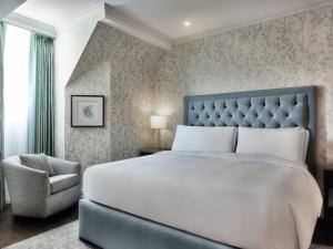 沃德勒伊多里翁沃德勒伊酒庄酒店的卧室配有一张白色大床和一把椅子
