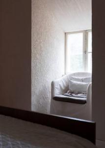 Tunnelmallinen kaksio hirsitalossa的窗户客房内的白色椅子