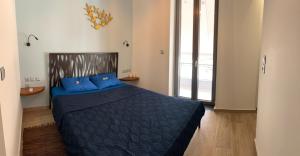 毕达哥利翁Pythagorion Harbour Residence的一间卧室配有一张带蓝色枕头的床