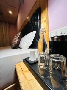 PalchānBurwa Breeze By Winsum Stays的床上的托盘,上面装有瓶子和玻璃杯
