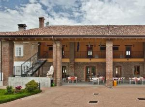 Borghetto LodigianoAntica Cascina B&B的一座大型砖砌建筑,设有阳台和桌子