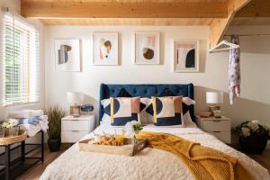 布兰德福德福鲁姆Copperbeech - Luxury Holiday with Private Hottub的一间卧室配有一张蓝色的床,上面有一盒水果