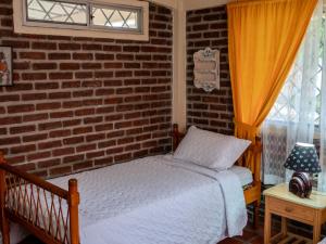 普拉亚斯Las villas de Yoly的一间卧室设有一张床和砖墙