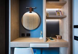 布勒伊-切尔维尼亚冰雪王子酒店的浴室设有镜子和蓝色的墙壁