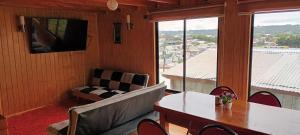 达卡卫Cabaña piedra azul的客厅配有桌子、沙发和电视