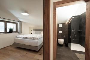 格罗萨尔Alpine Lofts M26的一间卧室配有一张床,浴室设有淋浴。