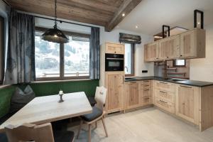 格罗萨尔Alpine Lofts M26的厨房配有木制橱柜和木桌。
