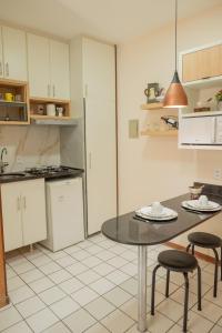 巴西利亚Studio Sudoeste Brasília的厨房配有桌子和两张凳子
